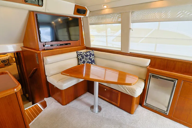  Yacht Photos Pics Interior of 2000 Riviera Flybridge Convertible yacht with dining area and TV.