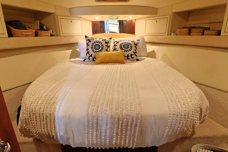  Yacht Photos Pics Cozy bedroom in 2000 Riviera Flybridge Convertible yacht with elegant bedding and storage.