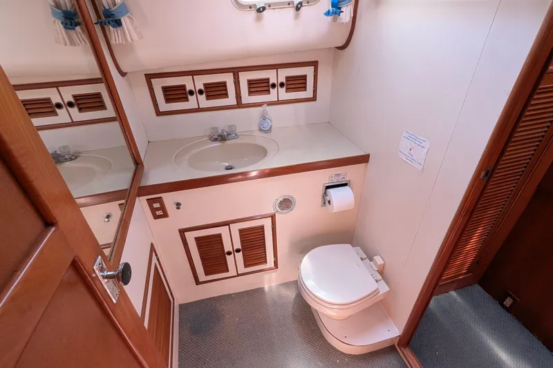 Fishers Folly IV Yacht Photos Pics 1988 Offshore Yachts 48 Yachtfisher bathroom with sink, mirror, and toilet.