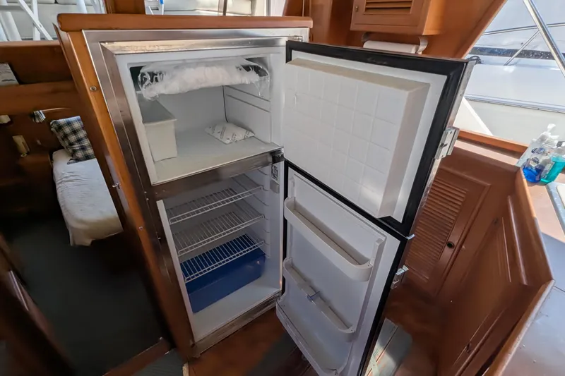 Fishers Folly IV Yacht Photos Pics Open refrigerator inside 1988 Offshore Yachts 48 Yachtfisher, showcasing interior storage space.