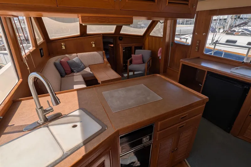 Fishers Folly IV Yacht Photos Pics Interior of 1988 Offshore Yachts 48 Yachtfisher with cozy seating and kitchen area.