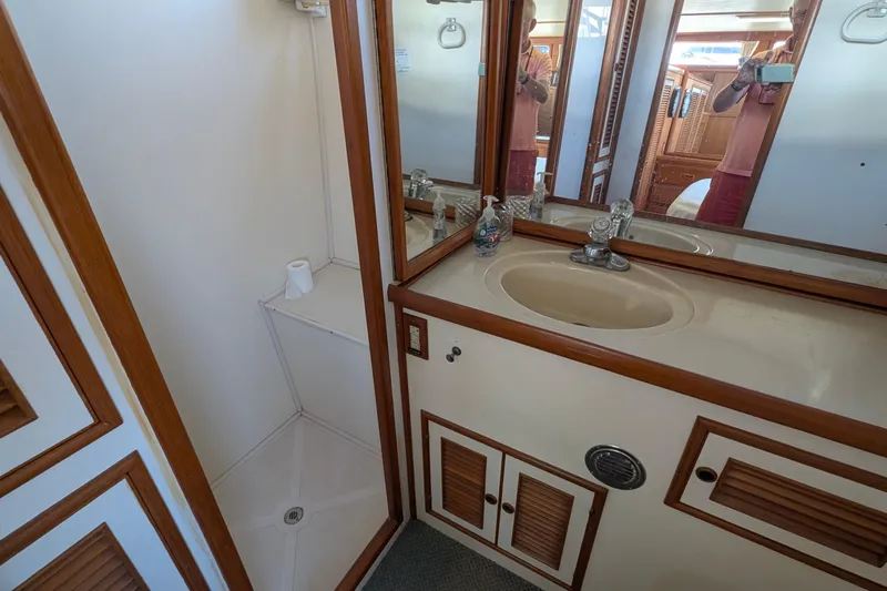 Fishers Folly IV Yacht Photos Pics Bathroom interior of 1988 Offshore Yachts 48 Yachtfisher, featuring sink and shower area.