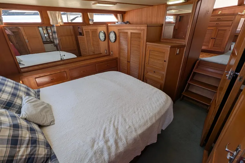 Fishers Folly IV Yacht Photos Pics 1988 Offshore Yachts 48 Yachtfisher cabin with wood paneling, bed, and nautical decor.