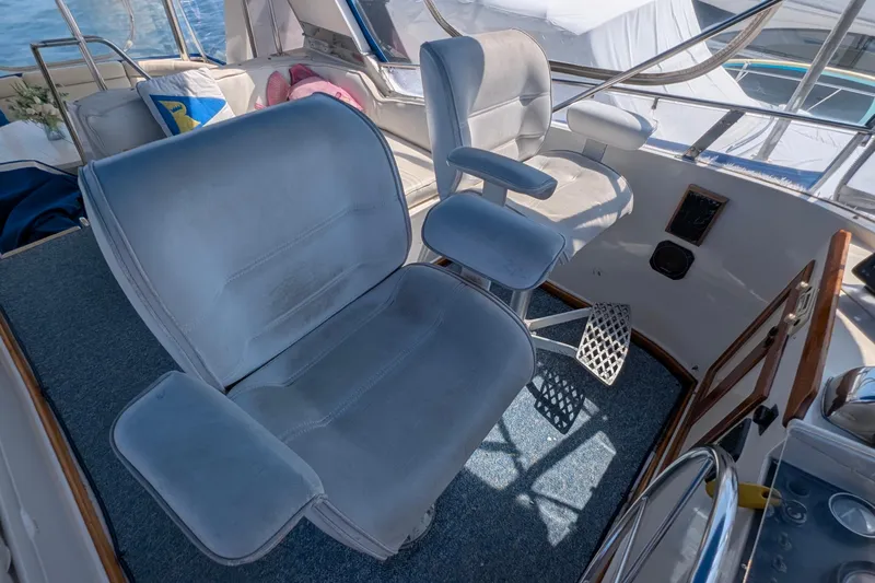 Fishers Folly IV Yacht Photos Pics Helm seating area on 1988 Offshore Yachts 48 Yachtfisher, featuring comfortable captain's chairs.
