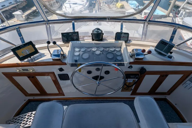 Fishers Folly IV Yacht Photos Pics Helm of 1988 Offshore Yachts 48 Yachtfisher with navigation instruments and steering wheel.