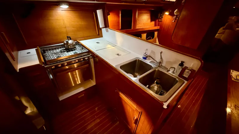 Elan Yacht Photos Pics 1989 J Boats J/40 yacht kitchen with stove, dual sinks, and wooden cabinetry.
