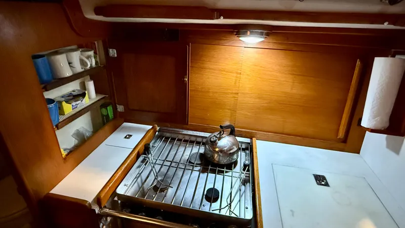 Elan Yacht Photos Pics 1989 J Boats J/40 yacht kitchen with stove, kettle, and wooden cabinetry.