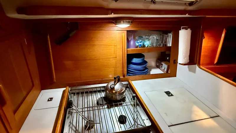 Elan Yacht Photos Pics 1989 J Boats J/40 yacht kitchen with stove, kettle, and wooden cabinetry.