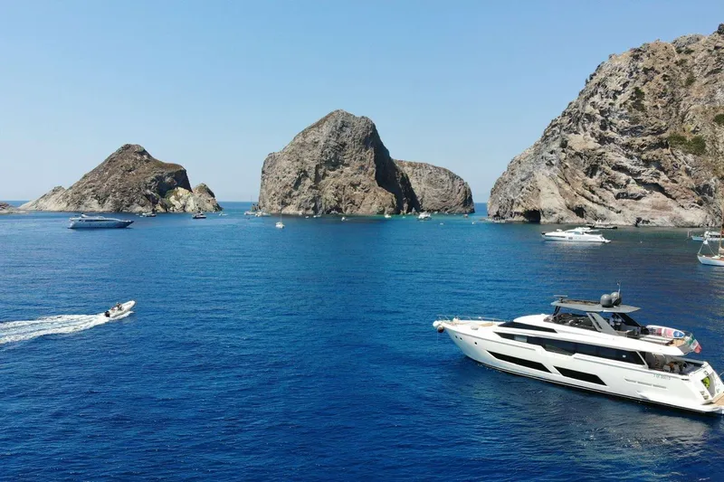 E3 Yacht Photos Pics 2019 Ferretti Yachts 850 cruising near rocky islands in clear blue waters.