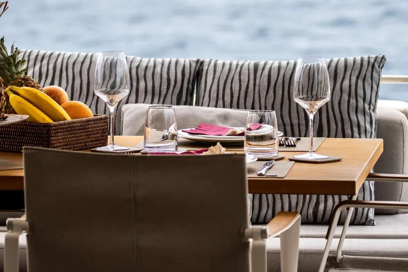 E3 Yacht Photos Pics Elegant dining setup on 2019 Ferretti Yachts 850, featuring fruit basket and wine glasses.