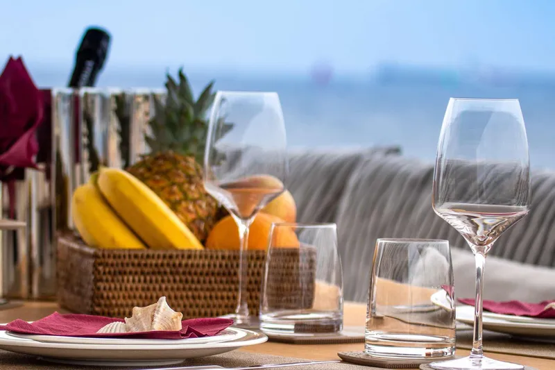 E3 Yacht Photos Pics Elegant dining setup on 2019 Ferretti Yachts 850 with fruit basket and wine glasses.
