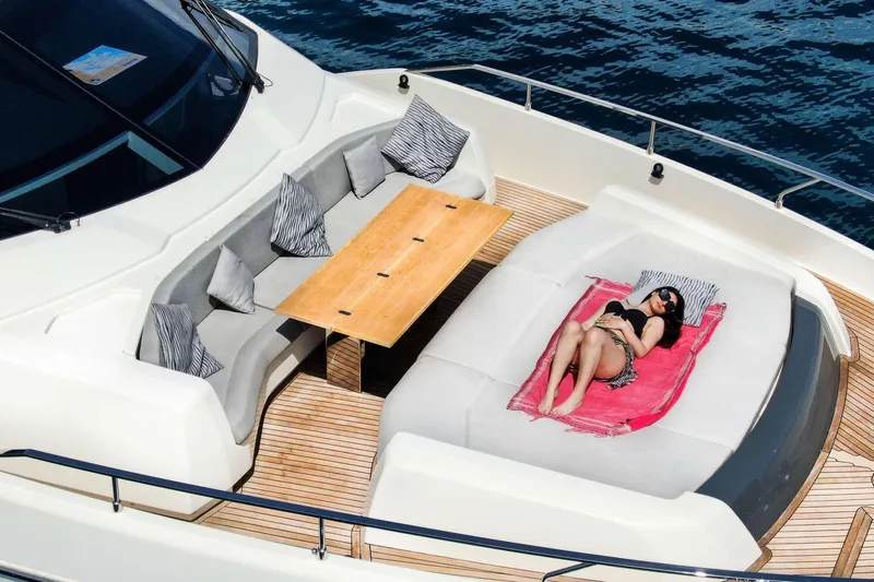 E3 Yacht Photos Pics 2019 Ferretti Yachts 850 deck with sunbathing area and seating, on calm water.