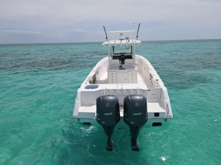 Knee Deep Yacht Photos Pics 2015 Everglades 325 Center Console boat on clear turquoise water, rear view.
