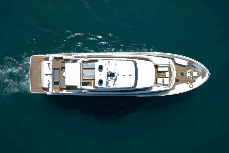  Yacht Photos Pics Aerial view of 2026 Nomad 101 yacht cruising on blue ocean waters.