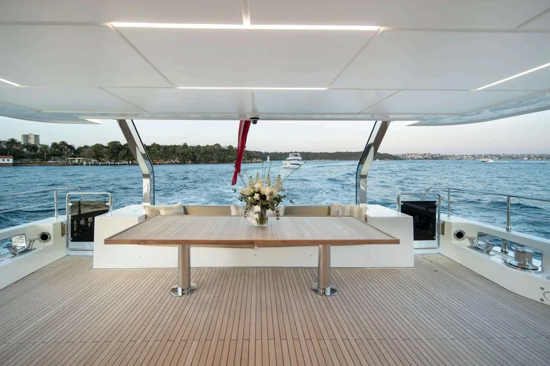  Yacht Photos Pics Luxurious Nomad 101 yacht deck with elegant table, ocean view, and floral centerpiece, 2026 model.
