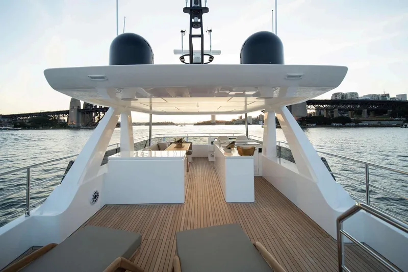  Yacht Photos Pics Luxurious Nomad 101 yacht deck, 2026 model, with elegant seating and scenic waterfront view.