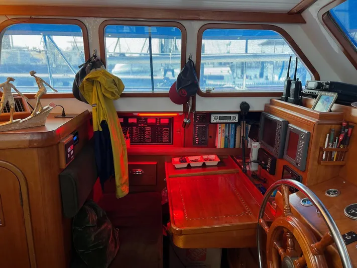 Aries Yacht Photos Pics Interior of 1982 Sea Star 46 boat with wooden helm, navigation equipment, and nautical decor.
