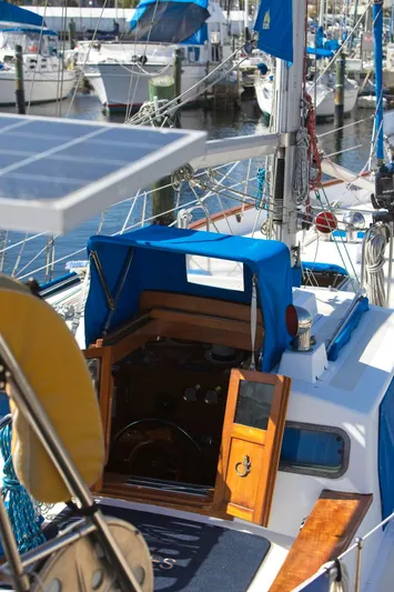 Aries Yacht Photos Pics 1982 Sea Star 46 sailboat with blue canopy, docked in marina.