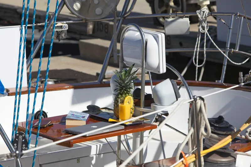 Aries Yacht Photos Pics Cockpit of 1982 Sea Star 46 sailboat with pineapple, book, and laptop on table.