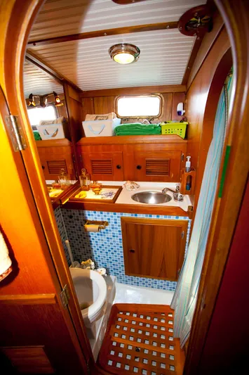 Aries Yacht Photos Pics 1982 Sea Star 46 yacht bathroom with wooden cabinetry, sink, and toilet.