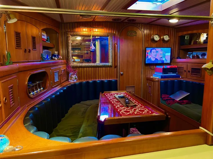 Aries Yacht Photos Pics Luxurious 1982 Sea Star 46 yacht interior with wood paneling, cozy seating, and a mounted TV.