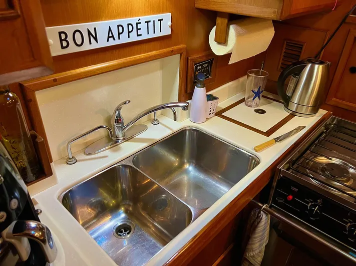 Aries Yacht Photos Pics 1982 Sea Star 46 yacht kitchen with dual sink, kettle, and 'Bon App&eacute;tit' sign.
