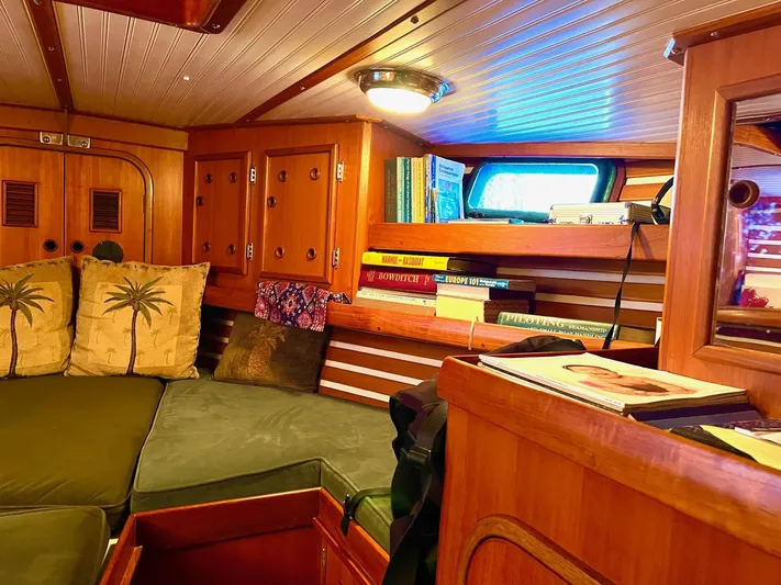 Aries Yacht Photos Pics Cozy 1982 Sea Star 46 yacht interior with wooden cabinetry, books, and green cushioned seating.