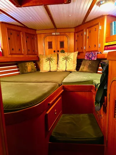 Aries Yacht Photos Pics Cozy cabin interior of 1982 Sea Star 46 yacht with wooden furnishings and green cushions.