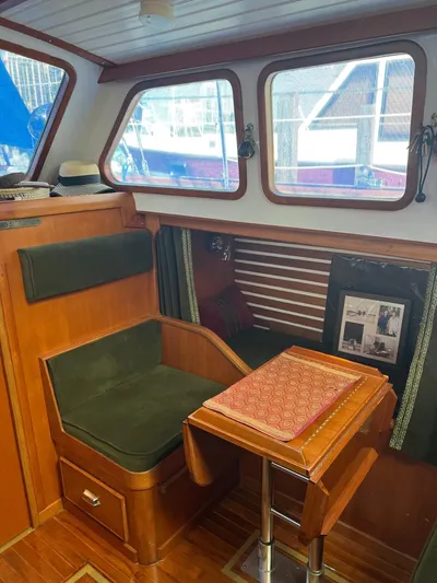 Aries Yacht Photos Pics Cozy 1982 Sea Star 46 boat interior with wooden seating and table, featuring large windows.
