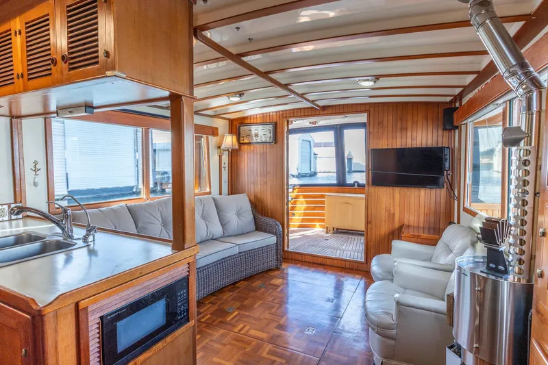 Points North III Yacht Photos Pics Interior of 1986 Kadey-Krogen 42 yacht with wood paneling, sofa, and kitchenette.