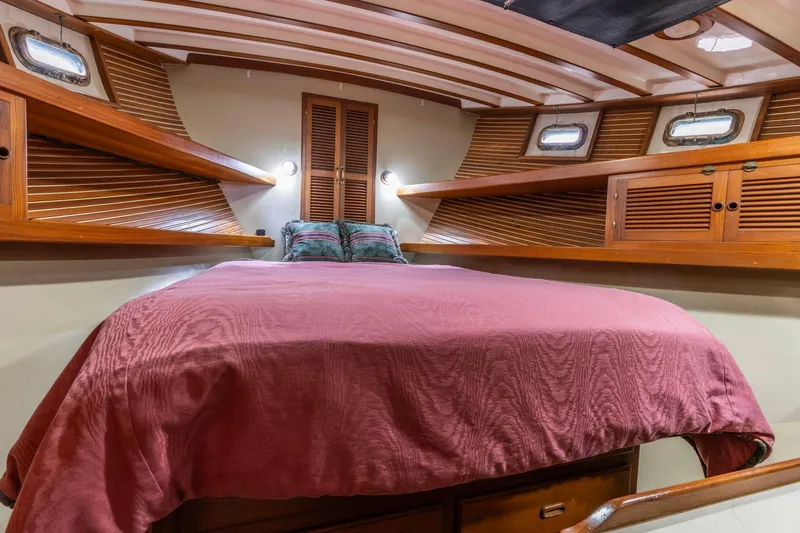 Points North III Yacht Photos Pics Cozy cabin interior of 1986 Kadey-Krogen 42 yacht with wooden accents and comfortable bedding.