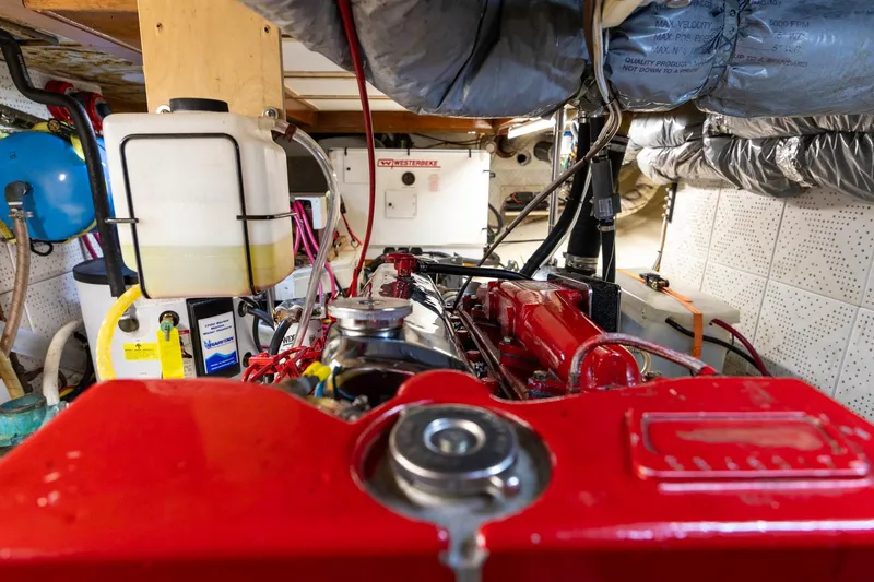 Points North III Yacht Photos Pics Engine room of a 1986 Kadey-Krogen 42 boat, featuring red machinery and various components.