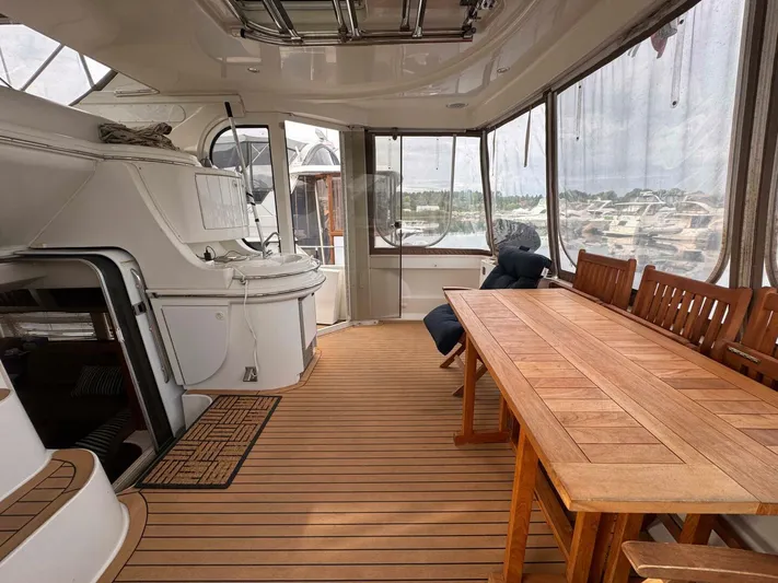  Yacht Photos Pics Spacious interior of 2002 Carver 466 Motor Yacht with wooden table and seating.