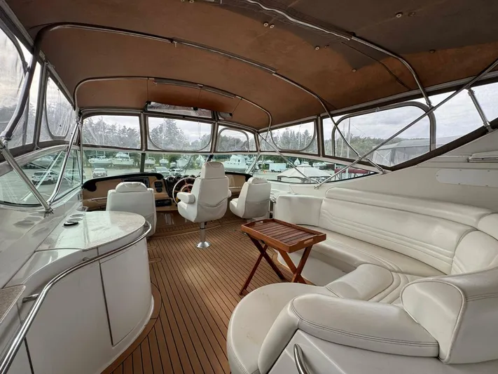  Yacht Photos Pics Luxurious interior of 2002 Carver 466 Motor Yacht with white seating and wooden table.