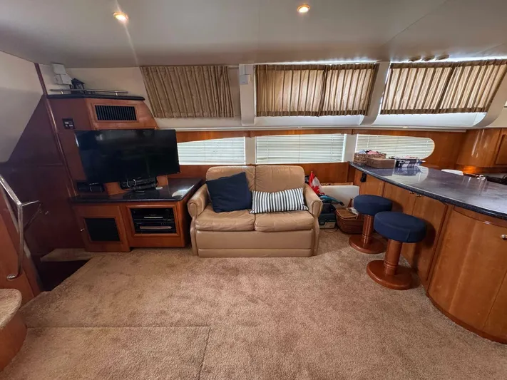  Yacht Photos Pics Interior of 2002 Carver 466 Motor Yacht with sofa, TV, and bar stools.