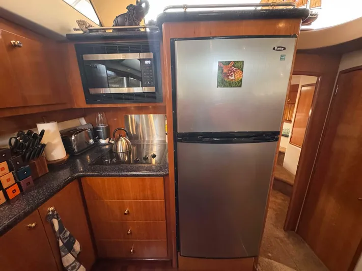  Yacht Photos Pics 2002 Carver 466 Motor Yacht kitchen with stainless steel appliances and wooden cabinetry.