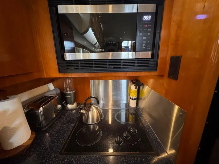  Yacht Photos Pics Compact kitchen area in 2002 Carver 466 Motor Yacht with microwave and stovetop.