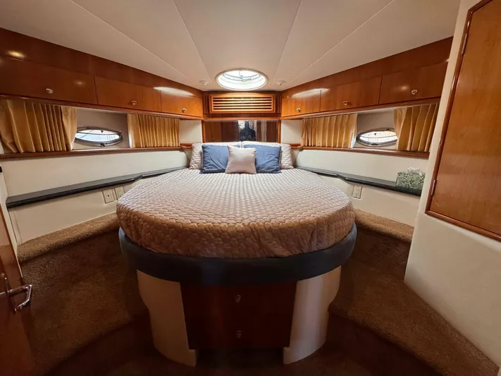  Yacht Photos Pics Luxurious bedroom interior of 2002 Carver 466 Motor Yacht with round bed and wood accents.