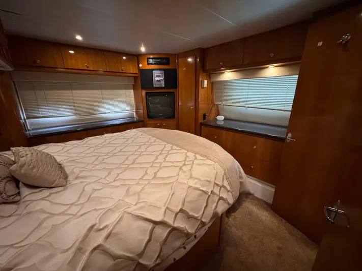  Yacht Photos Pics Luxurious bedroom interior of 2002 Carver 466 Motor Yacht with cozy bedding and wood finishes.