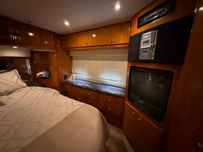 Yacht Photos Pics Luxurious 2002 Carver 466 Motor Yacht bedroom with wood cabinetry and entertainment system.