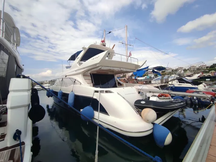  Yacht Photos Pics 2007 Azimut 62 yacht docked at marina with blue fenders and clear sky.