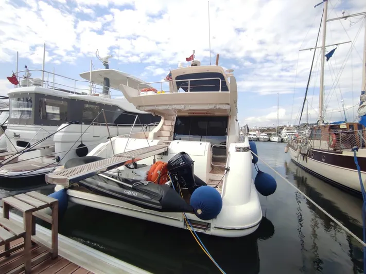  Yacht Photos Pics 2007 Azimut 62 yacht docked at marina, featuring inflatable boat and blue fenders.