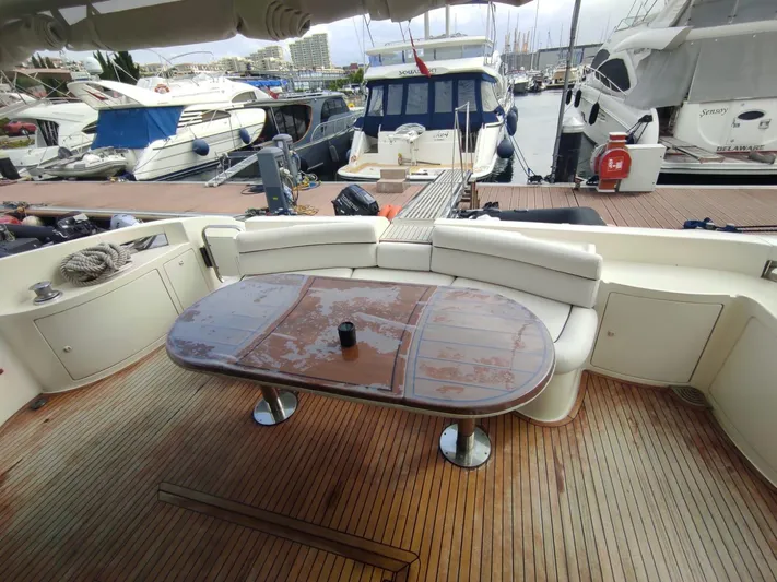  Yacht Photos Pics Luxurious 2007 Azimut 62 yacht deck with seating and table, docked at marina.