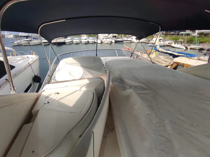  Yacht Photos Pics 2007 Azimut 62 yacht with covered seating area, docked in a marina.