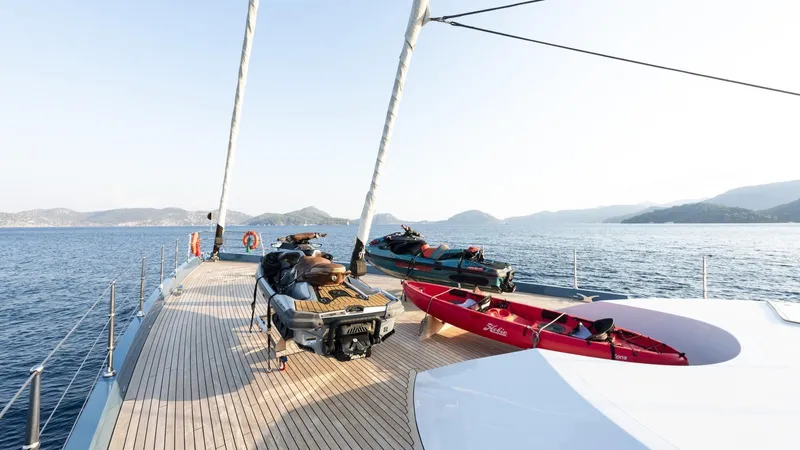 All About U Yacht Photos Pics Luxurious 2018 Ada Yacht deck with jet skis and kayak, sailing on serene waters.