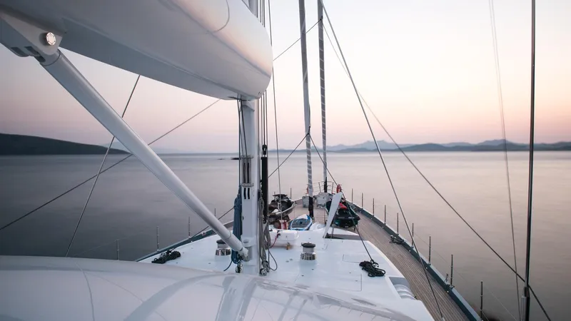 All About U Yacht Photos Pics Sailing yacht deck at sunset, Ada Yacht 2018 model, serene ocean view.