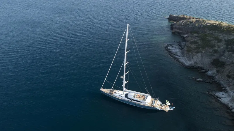 All About U Yacht Photos Pics Aerial view of 2018 Ada Yacht sailing near rocky coastline.