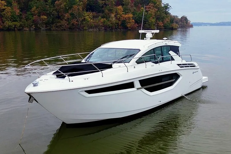  Yacht Photos Pics 2020 Cruisers Yachts 42 Cantius on calm water, surrounded by autumn trees.