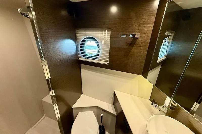  Yacht Photos Pics Luxurious bathroom interior of 2020 Cruisers Yachts 42 Cantius with modern fixtures and porthole window.