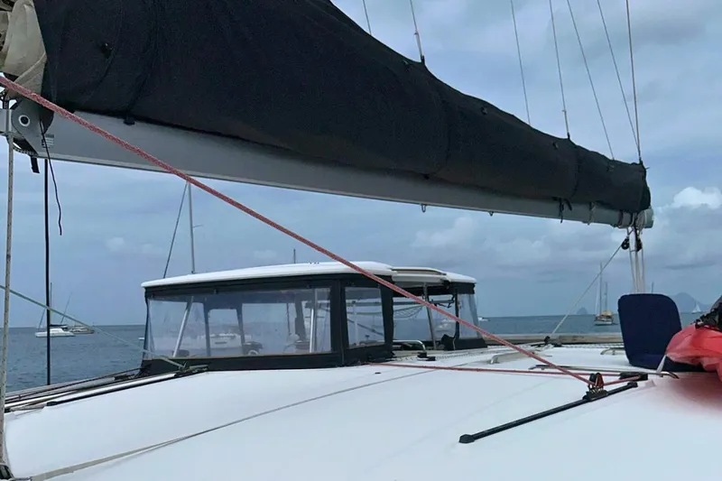 Sixtus Yacht Photos Pics Lagoon 450 s catamaran, 2016 model, with sails furled, anchored in calm waters.